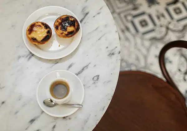 pastel de nata and a coffee in a cafe table