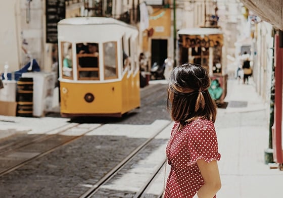 girl in a Lisbon street with a tram