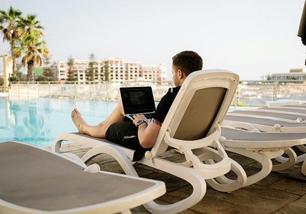digital nomad working near a pool